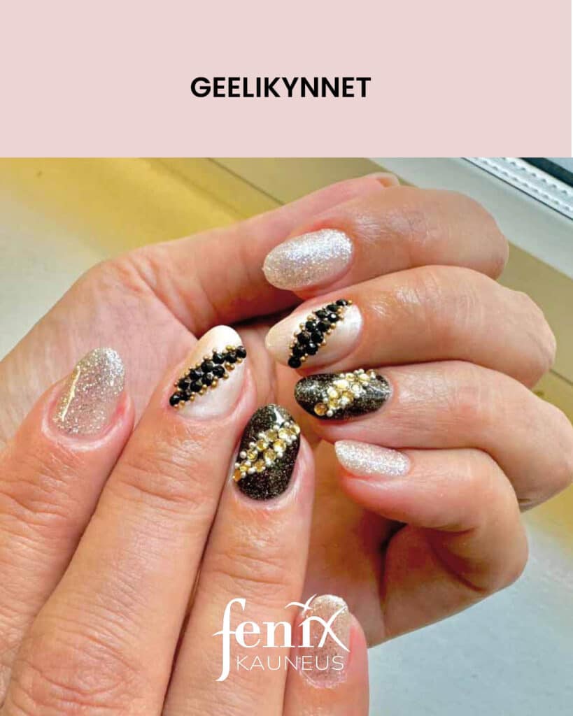 Lyhyet glittergeelirakennekynnet, joissa mustaa ja valkoista glitteria, seka mustia, valkoisia ja kultaisia timantteja.