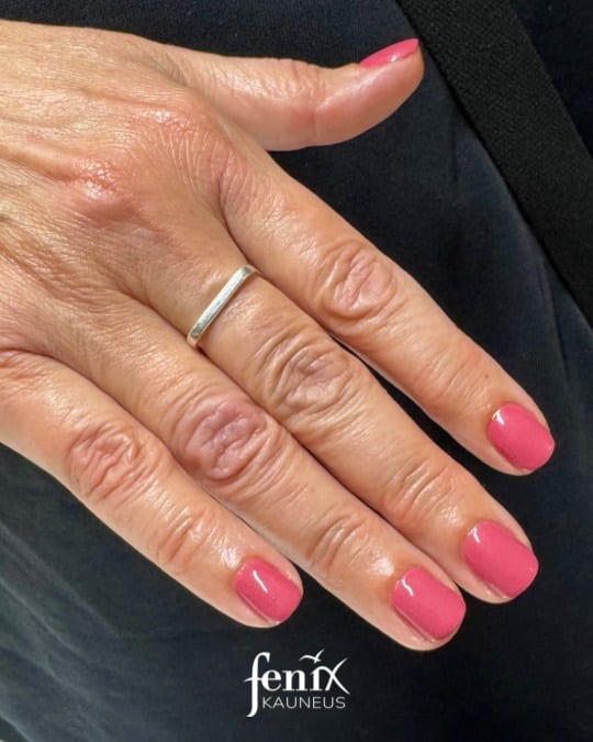 Marjapuuron värinen geelilakkaus sormissa.